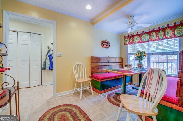 dining area with ceiling fan, ornamental molding, and a textured ceiling