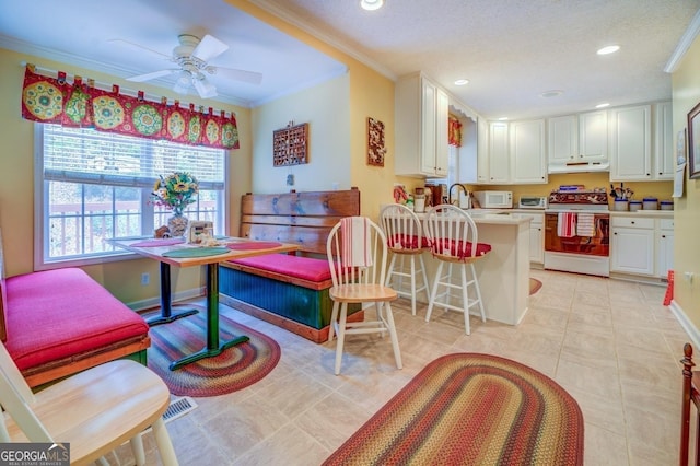 interior space featuring ornamental molding, range with electric cooktop, white cabinetry, light countertops, and under cabinet range hood