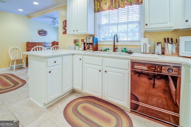 kitchen with white cabinets, a sink, white microwave, black dishwasher, and ceiling fan