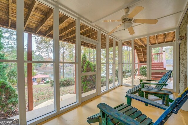 sunroom / solarium with a water view, ceiling fan, and lofted ceiling