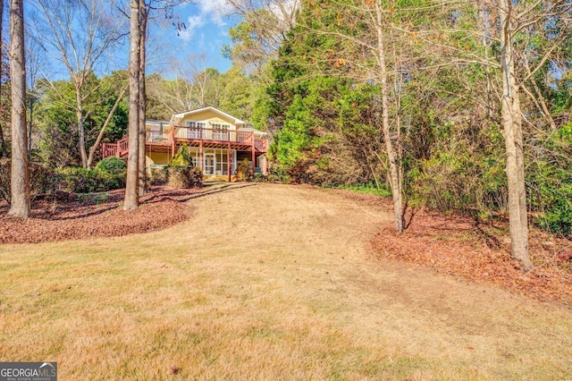 view of yard featuring a wooden deck and a wooded view