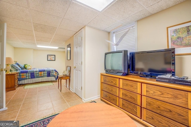 bedroom with light tile patterned floors and a drop ceiling