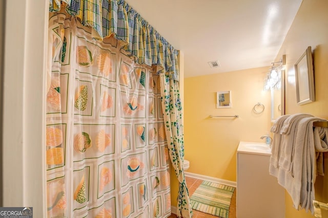 bathroom featuring tile patterned floors, vanity, baseboards, toilet, and visible vents