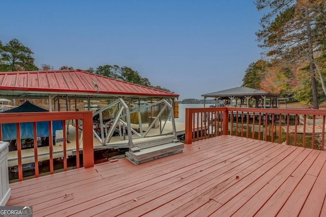 wooden deck featuring a gazebo, boat lift, and a dock