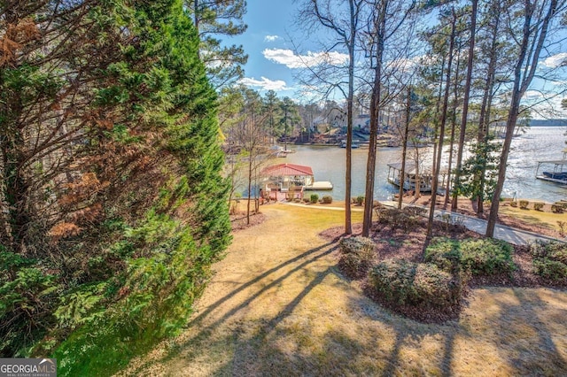 view of yard featuring a boat dock and a water view