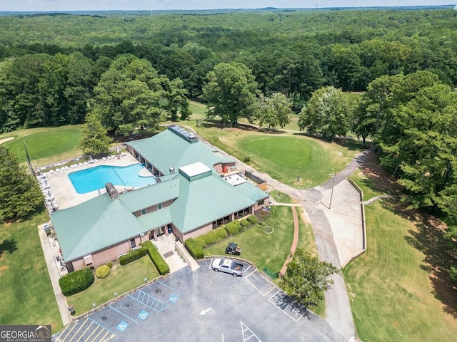 birds eye view of property with golf course view and a wooded view