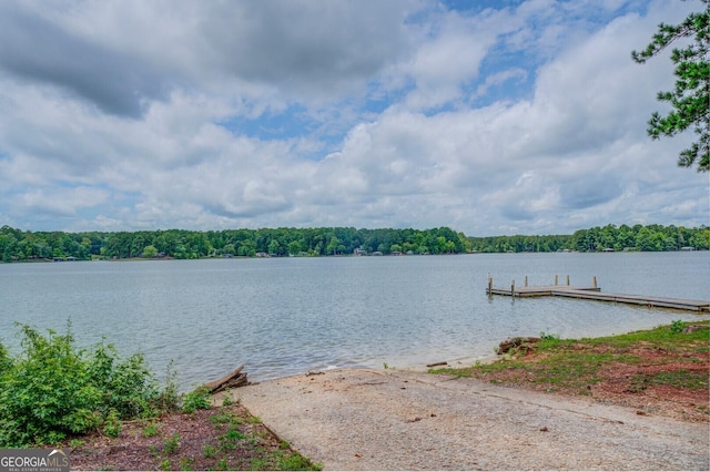 view of dock featuring a water view and a wooded view