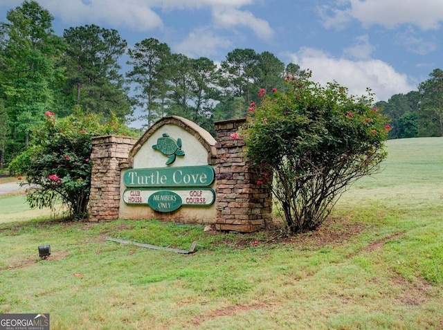 community / neighborhood sign featuring a yard