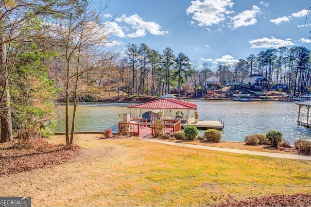 view of dock with a lawn, a gazebo, and a water view