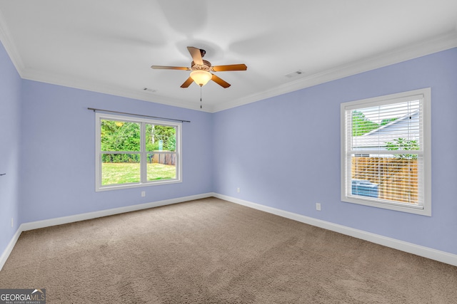 carpeted empty room featuring plenty of natural light, ornamental molding, and ceiling fan