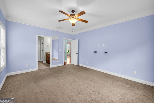 unfurnished bedroom with ceiling fan, ornamental molding, light carpet, and ensuite bath