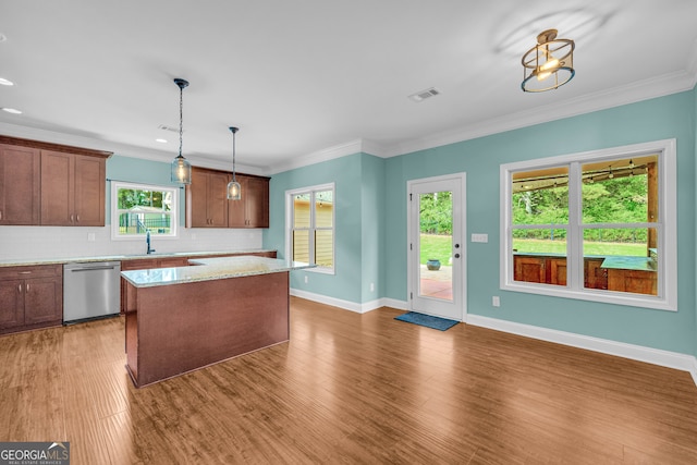 kitchen with dishwasher, backsplash, crown molding, pendant lighting, and a kitchen island