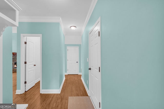 corridor with crown molding and light hardwood / wood-style floors