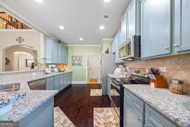 kitchen with decorative backsplash, light stone countertops, stainless steel appliances, dark wood-type flooring, and crown molding