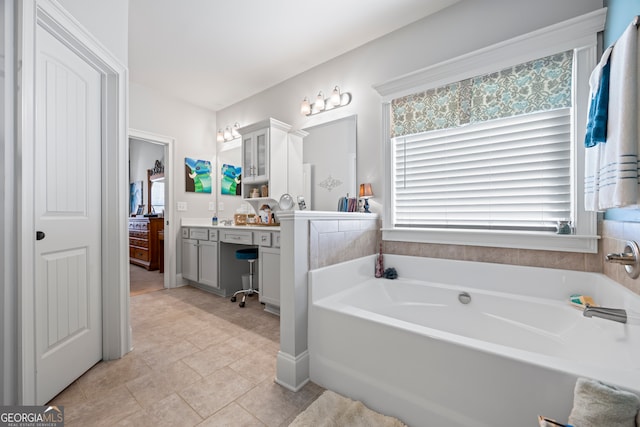 bathroom with tile patterned floors, a bathtub, and vanity