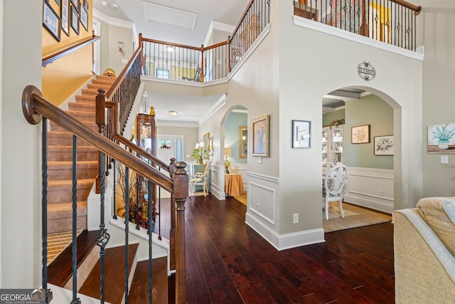 entryway featuring crown molding, hardwood / wood-style floors, and a high ceiling