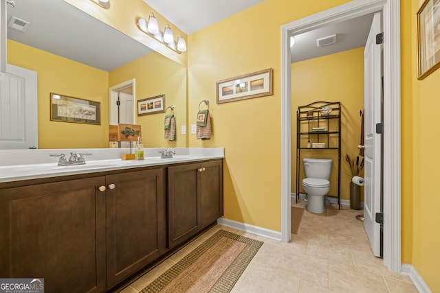 bathroom featuring tile patterned flooring, vanity, and toilet