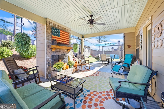 view of patio / terrace with an outdoor living space with a fireplace and ceiling fan