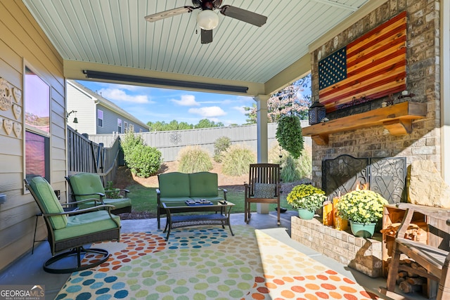 view of patio / terrace with an outdoor living space with a fireplace and ceiling fan