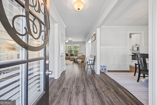 foyer entrance with ceiling fan, dark hardwood / wood-style flooring, and crown molding