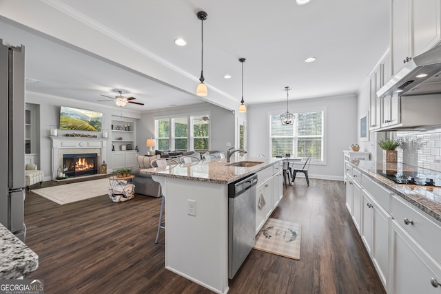 kitchen with white cabinetry, light stone counters, stainless steel dishwasher, a kitchen island with sink, and a breakfast bar