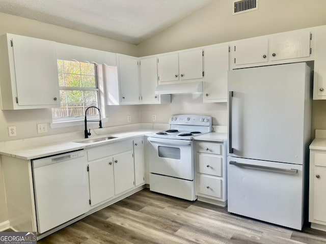 kitchen with light hardwood / wood-style floors, white appliances, lofted ceiling, white cabinets, and sink