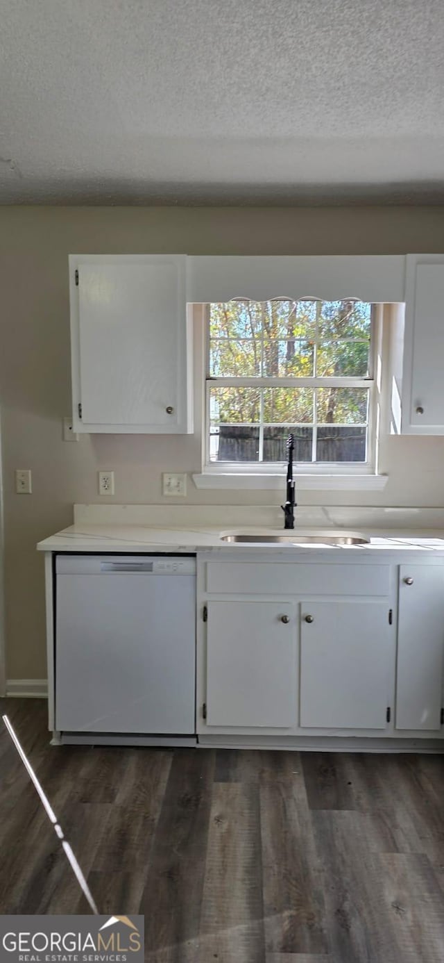 kitchen featuring a textured ceiling, white cabinetry, dishwasher, and sink