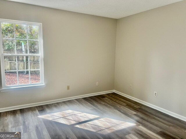 unfurnished room featuring dark hardwood / wood-style floors and a textured ceiling