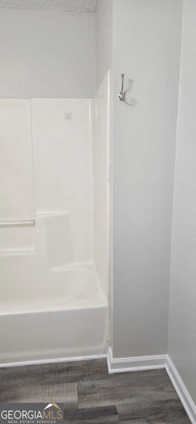 bathroom featuring bathing tub / shower combination and hardwood / wood-style floors