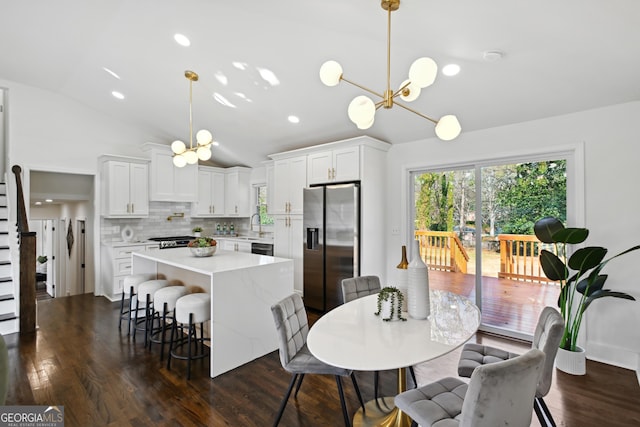 dining space with lofted ceiling, dark wood-type flooring, and a notable chandelier