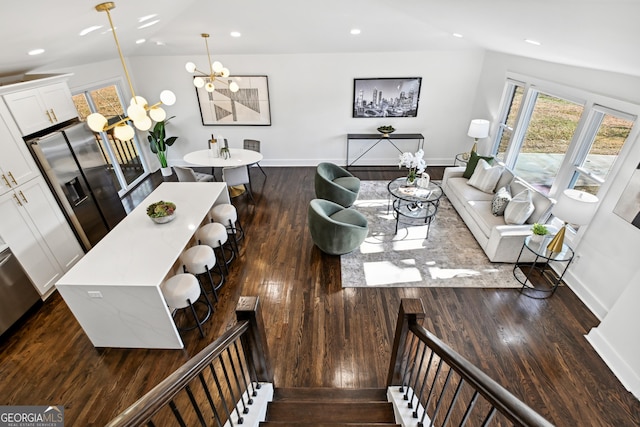 living room featuring lofted ceiling, dark hardwood / wood-style floors, and a chandelier