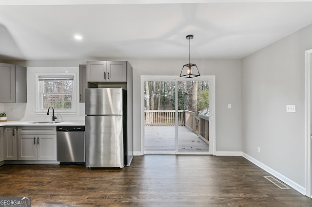 kitchen featuring gray cabinets, sink, stainless steel appliances, and hanging light fixtures