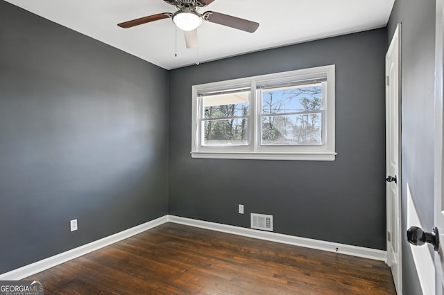 spare room featuring dark hardwood / wood-style flooring and ceiling fan