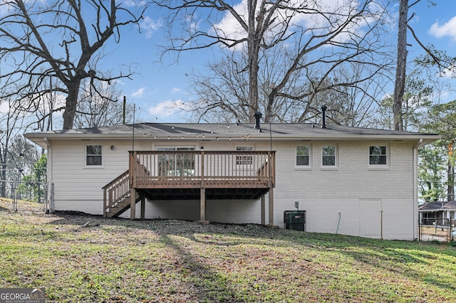 rear view of property with cooling unit, a deck, and a yard