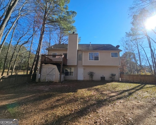 rear view of house featuring a yard, cooling unit, a deck, and a storage shed