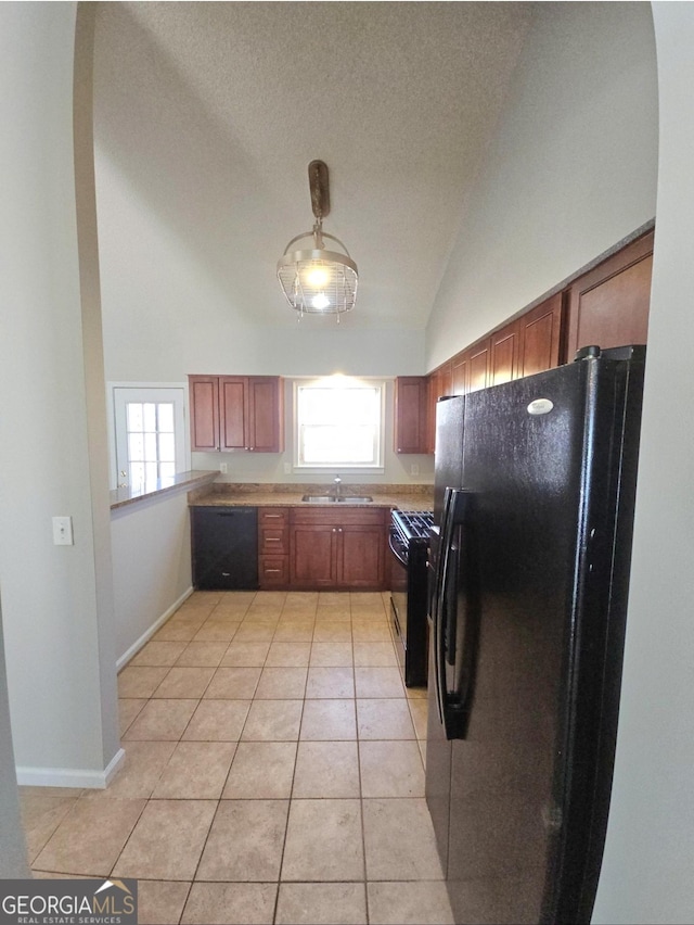 kitchen featuring sink, light tile patterned floors, black appliances, and high vaulted ceiling