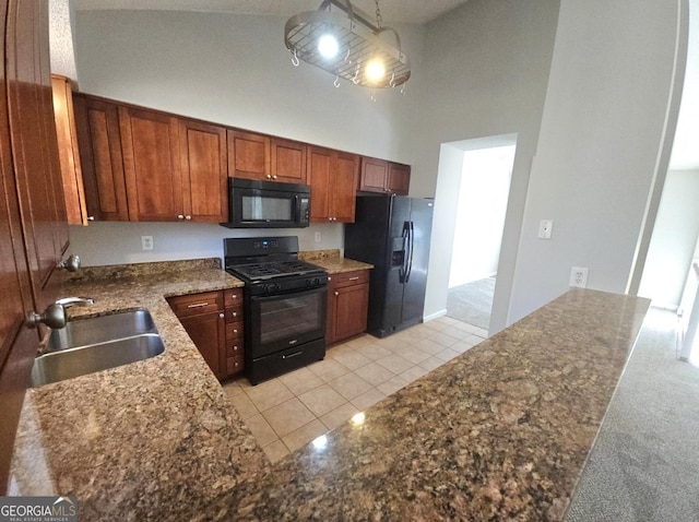 kitchen with sink, black appliances, light tile patterned floors, a high ceiling, and hanging light fixtures