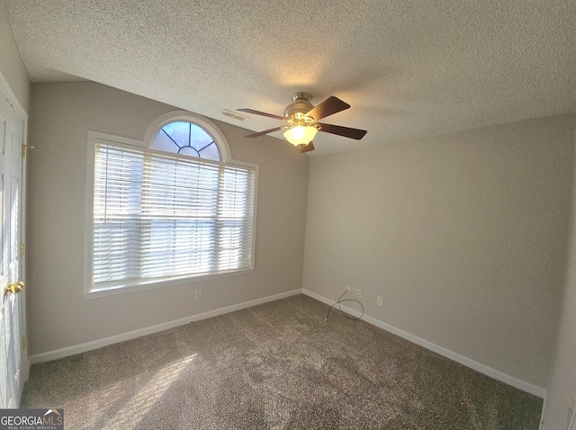 carpeted spare room with ceiling fan and a textured ceiling