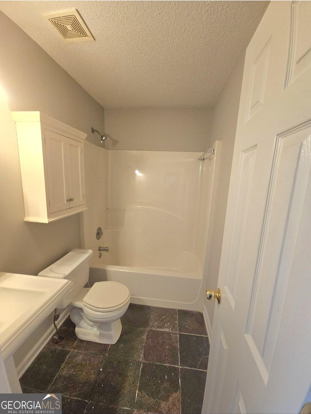 full bathroom with shower / tub combination, sink, a textured ceiling, and toilet