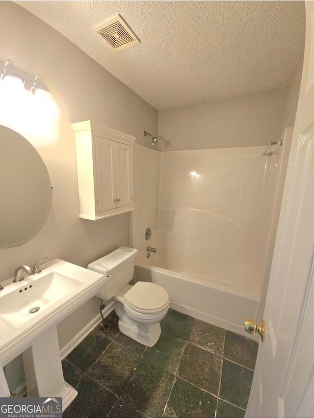 bathroom featuring a textured ceiling,  shower combination, and toilet