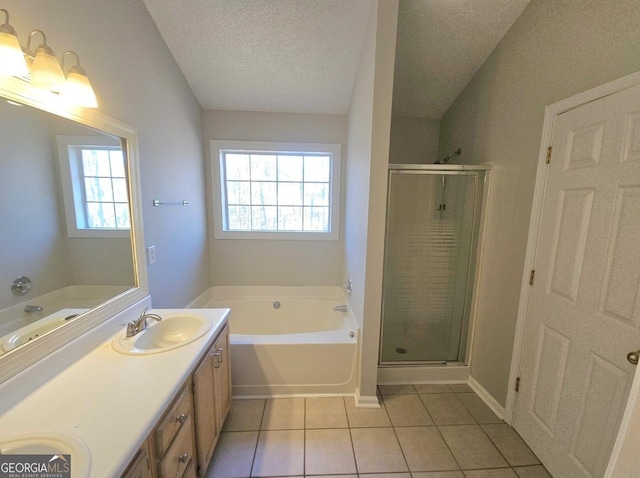 bathroom featuring vanity, a textured ceiling, tile patterned floors, and a healthy amount of sunlight