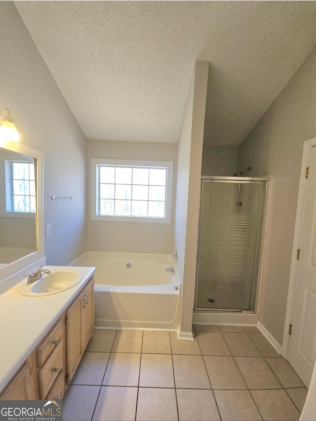 bathroom with vanity, a textured ceiling, tile patterned floors, and a wealth of natural light