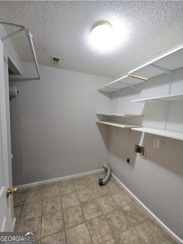 washroom featuring washer hookup, a textured ceiling, and electric dryer hookup