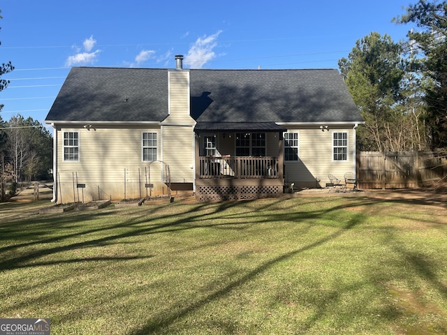 back of property featuring a lawn and a deck