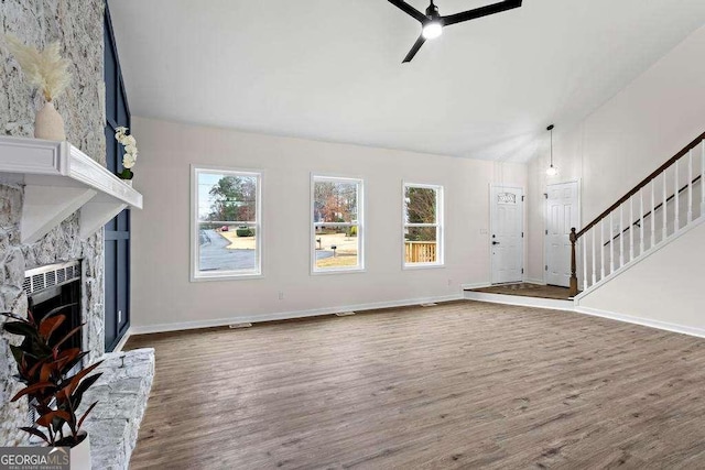 unfurnished living room with a premium fireplace, ceiling fan, dark wood-type flooring, and lofted ceiling