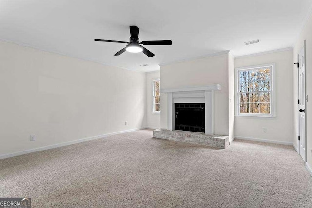 unfurnished living room with ceiling fan, crown molding, light carpet, and a brick fireplace