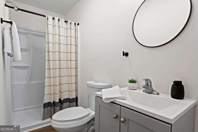 bathroom featuring vanity, toilet, and curtained shower