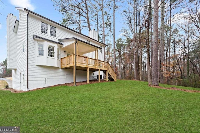 rear view of property featuring a wooden deck and a yard