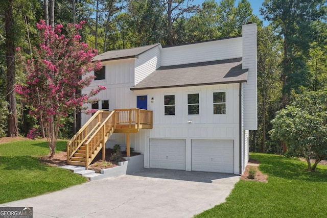 view of front of property with a garage, a front lawn, and a wooden deck