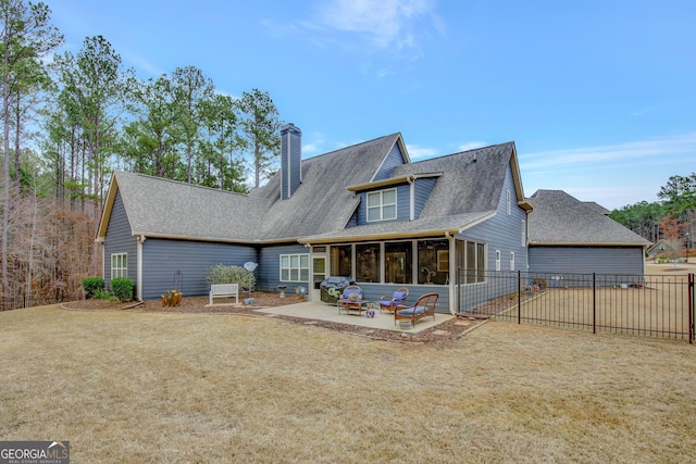 rear view of house featuring a sunroom and a patio